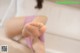 A woman sitting in a bathtub with her feet up.