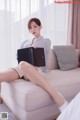 A woman sitting on a couch holding a laptop computer.